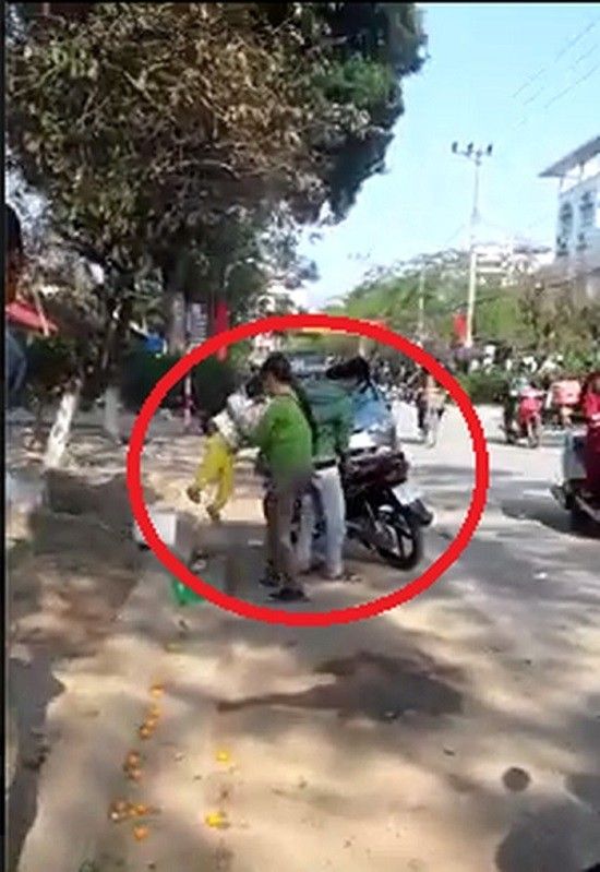 Đứa bé bị người bà nội ném vào sọt rác bên đường. Ảnh cắt từ clip