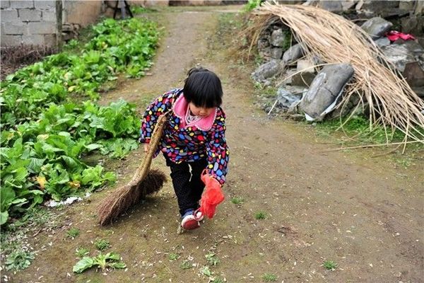 Miaomiao sweeps the road to her home, in an isolated village in Yichang city, Central China's Hubei province, Feb 23. Parentless, the first-grader has taken up a lot of resposibility in the family. Her grandmother, who is approaching her 60s, is mentally disabled, handicapped in the right arm, and is frail. Her grandfather suffered severe cracked skin disease, which makes him unable to be exposed to water especially in the winter.